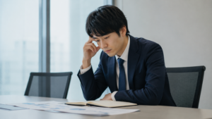仕事の振り返りをしているが、少し考え込み、自分の欠点ばかり探しているような表情