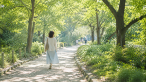 木漏れ日の遊歩道を一人でゆっくり歩く女性